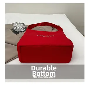 Detail view of the durable reinforced flat bottom on the red canvas tote bag