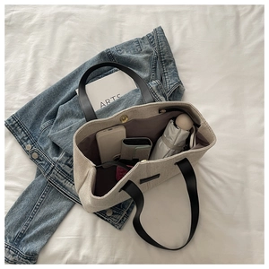 Detail of beige tote bag interior with magnetic closure and brown lining storage capacity