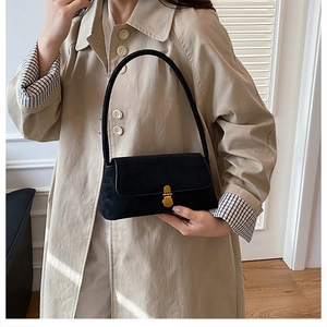 Dettaglio della borsa baguette nera opaca vintage con elegante fibbia in metallo oro