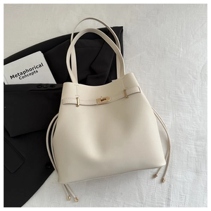 Close-up of off-white tote bag featuring matte finish and drawstring with metal turn lock