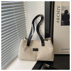 Détail du grand sac cabas en toile beige avec double anse en cuir noir chic