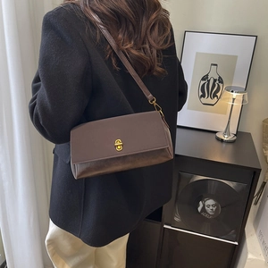 Brown leather square flap shoulder bag with gold oval lock on a black blazer outfit