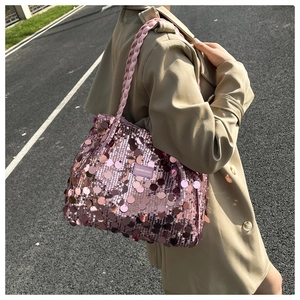Detail of pink sequin tote bag with woven handle and luxury texture in natural sunlight