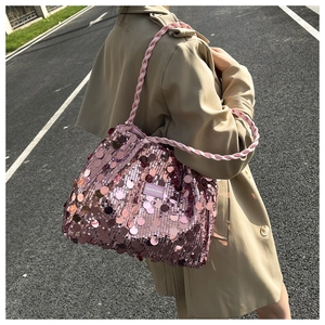 Close-up of a pink sequin shoulder bag with woven handle and Fashion & Bags logo tag