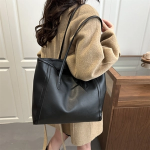 Classic large black leather tote bag for women showing a minimalist shoulder carry style