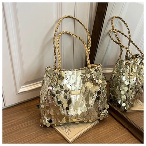 Detailed shot of golden sequin tote bag with FASHION & BAGS metal logo on wooden surface