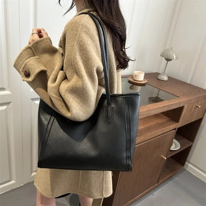 Minimalist black faux leather tote bag with long shoulder straps for elegant women