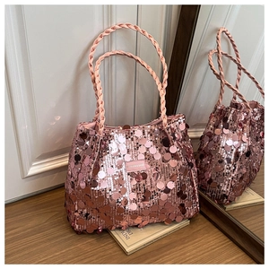 Close-up of pink sequined handbag featuring woven handle and a fashion logo label