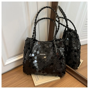 Detail of black sequined tote bag with woven handles and metallic logo plate