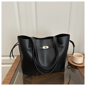 Detail of black leather bucket bag featuring a gold metal twist lock and side drawstrings