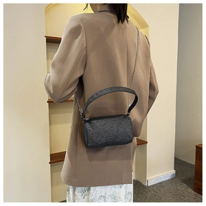 Détail du sac polochon cylindrique noir scintillant avec bandoulière chaîne argentée