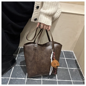 Détail du grand sac cabas vintage marron foncé avec sangle réglable et breloque chiot