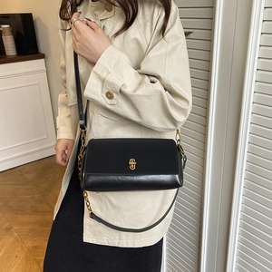 Minimalist black leather crossbody bag with golden twist lock and chain strap detail