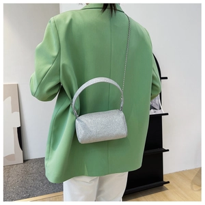 Détail du sac cylindrique à paillettes argentées avec poignée et bandoulière chaîne