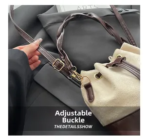 Detail showing the adjustable golden buckle and leather strap of the bucket bag