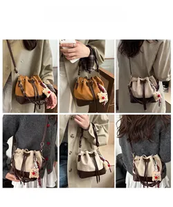 Detail of canvas drawstring bucket bag with leather base and plush star charm accessory
