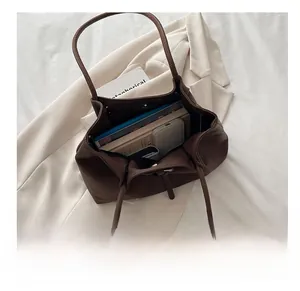 Detail showing the large capacity of the brown leather tote bag with daily essentials