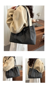 Matte black tote bag with buckle detail styled with a beige coat and white dress