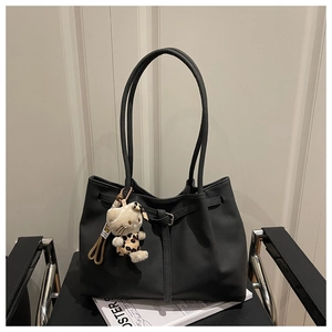 Macro detail of black matte tote bag with leopard print kitten plush charm accessory