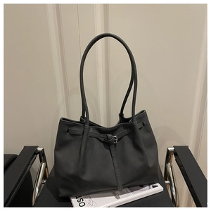 Detail of dark gray tote bag with buckle decor and matte leather texture on a chair