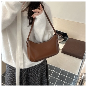 Detail of vintage brown underarm bag with SENSE LABELS embossing on premium PU leather