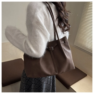 Close-up of a dark brown pleated tote bag with fine straps and silver buckle detail