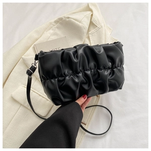Detailed macro shot of black pleated cloud bag with soft PU leather texture and silver rings