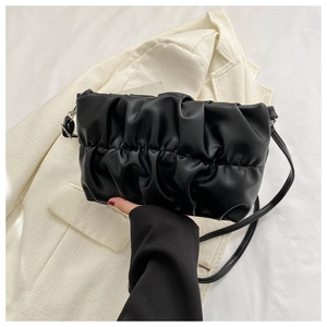 Detail of black pleated cloud bag with elegant accordion folds and slender shoulder strap