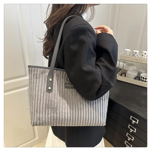 Dettaglio della borsa tote in velluto a coste grigio con texture e spalline sottili