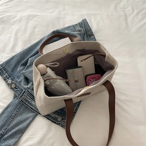 Linen canvas tote bag with brown leather handles and large capacity storage for daily items