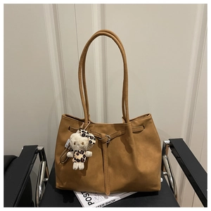 Brown vintage tote bag detail with drawstring closure and plush leopard toy charm