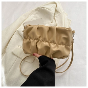 Detail of a beige pleated handbag showing soft faux leather texture and elegant clouds design