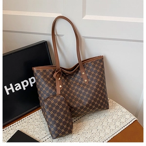 Détail d'un grand sac cabas marron à motifs géométriques avec sa pochette sur dentelle