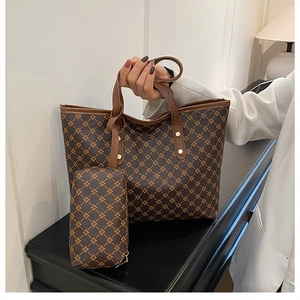 Détail d'un grand sac cabas avec motif monogramme marron et petite pochette assortie incluse