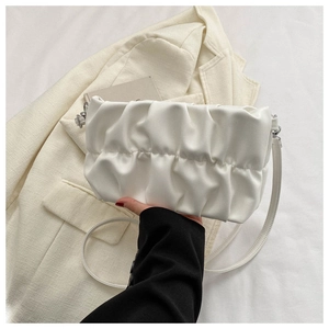 Detail of white pleated cloud bag with soft faux leather texture and slender shoulder strap