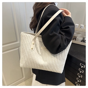 Dettaglio della borsa tote in velluto a coste bianco crema con cinturini in pelle