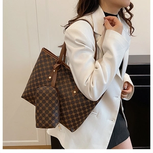 Vue détaillée du sac cabas marron avec motifs dorés et petite pochette assortie