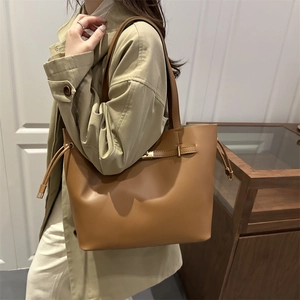 Brown faux leather bucket bag with tassels and metallic buckle for daily use