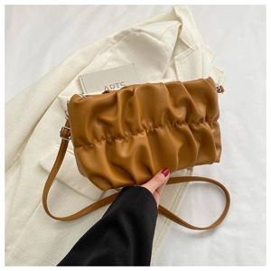 Detail of caramel pleated cloud bag featuring soft leather texture and adjustable strap