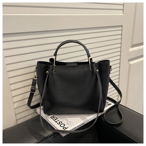 Detail der schwarzen Handtasche aus Leder mit goldener Hardware und abnehmbarem Gurt