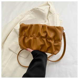 Detail view of the soft pleated texture and slim shoulder strap of the brown cloud bag