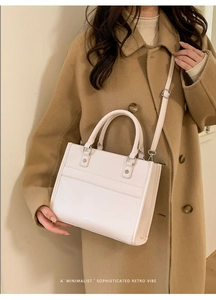Borsa tote beige abbinata a un cappotto color cammello con dettaglio tracolla regolabile