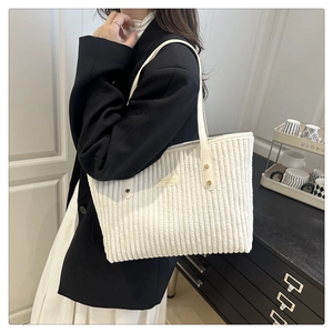 Détail de la texture velours et de la bandoulière en cuir sur un sac fourre-tout crème