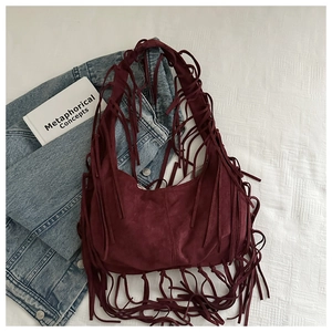 Detailed close-up of burgundy fringe tote bag with soft suede texture and boho styling