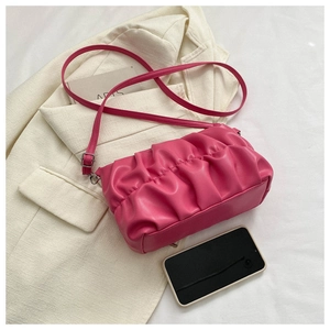 Detailed top view of magenta pleated cloud bag with phone for size reference