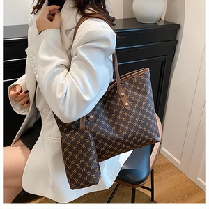 Détail d'un grand sac fourre-tout avec pochette assortie sur mannequin en blazer blanc