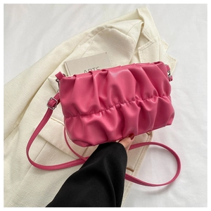 Detail of rose pink pleated cloud bag with soft leather texture and adjustable strap