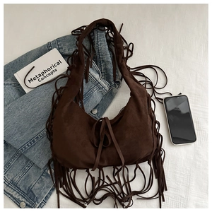 Close-up of bohemian dark brown suede shoulder bag with retro fringe and moon shape