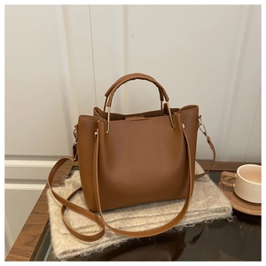 Close-up of brown litchi pattern leather tote bag with elegant gold metal hardware details
