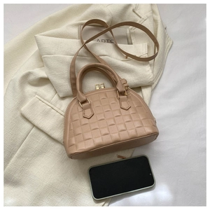 Vista superior de bolso tipo concha beige con relieve de cocodrilo y oro